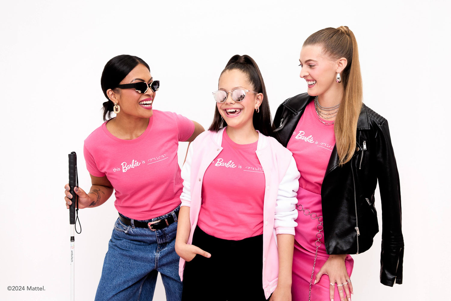Three blind models pose together in their pink Barbie braille t-shirts