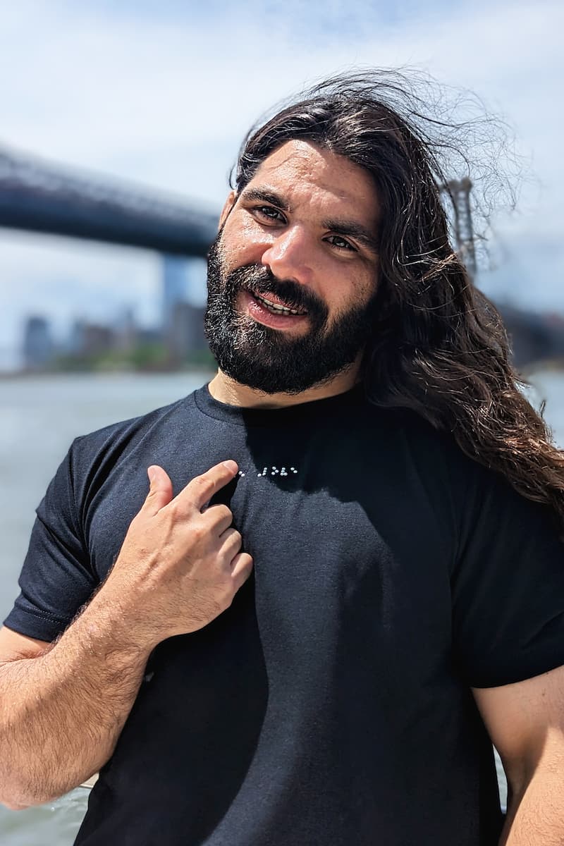 Anthony Ferraro reads braille on black t-shirt he is wearing