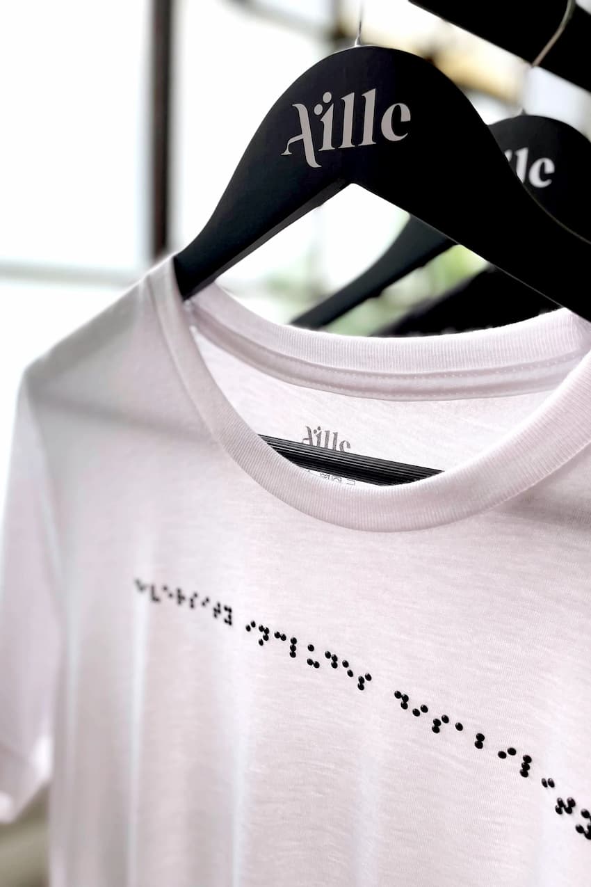 White and black braille shirt on custom braille hanger