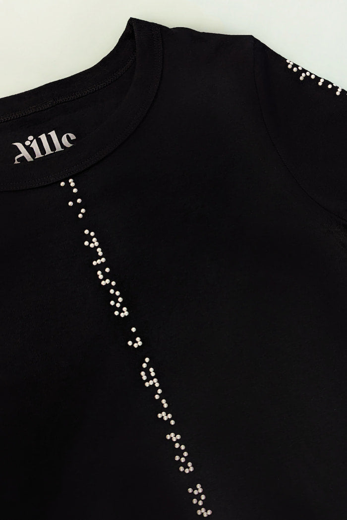 Close up of white braille on black shirt