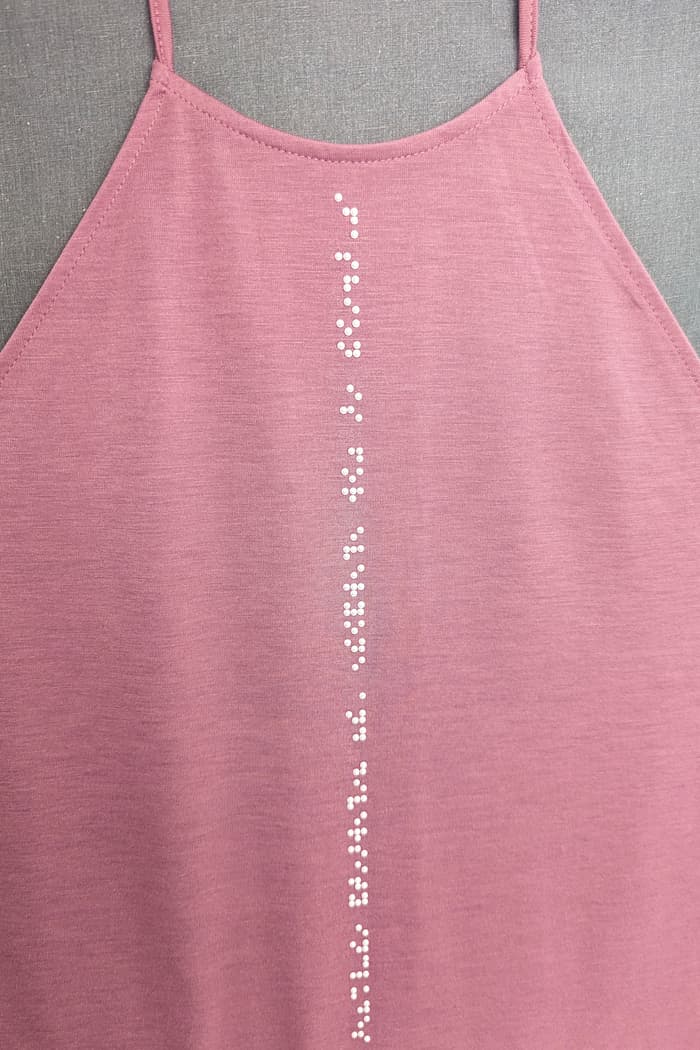 White braille on pink tank top