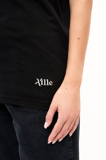 Logo Detail on Black T-Shirt: Close-up of the bottom corner of a black t-shirt showing the "Aille" logo in white embroidery