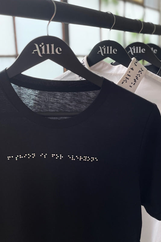 Black braille t-shirt on custom braille hanger