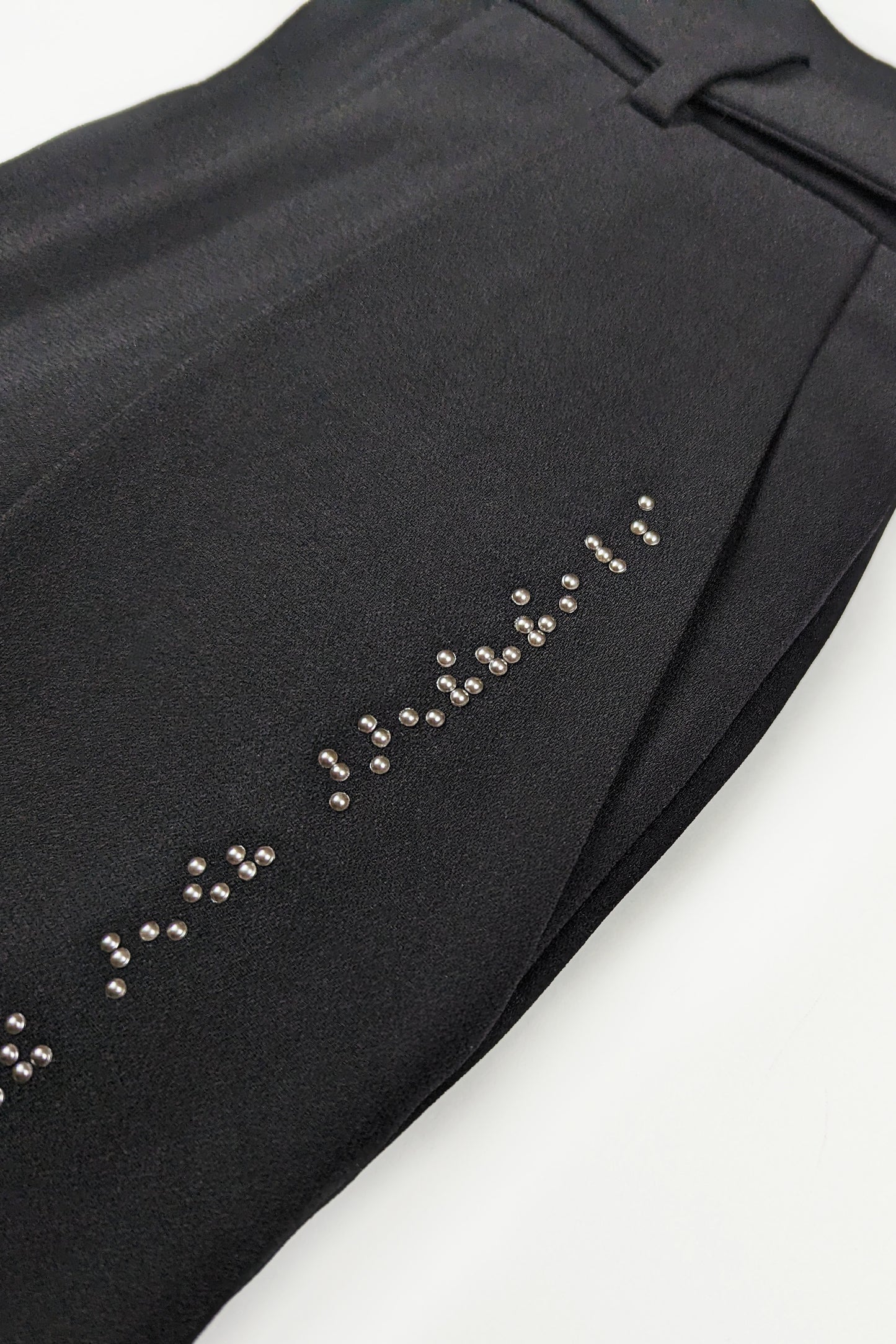 Close up of dark grey braille and pant pocket