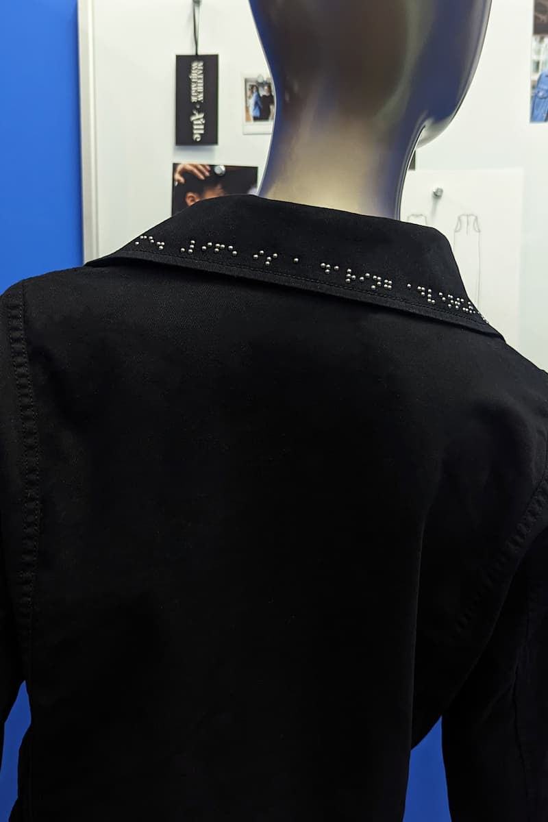 Dark grey braille on back of jacket collar