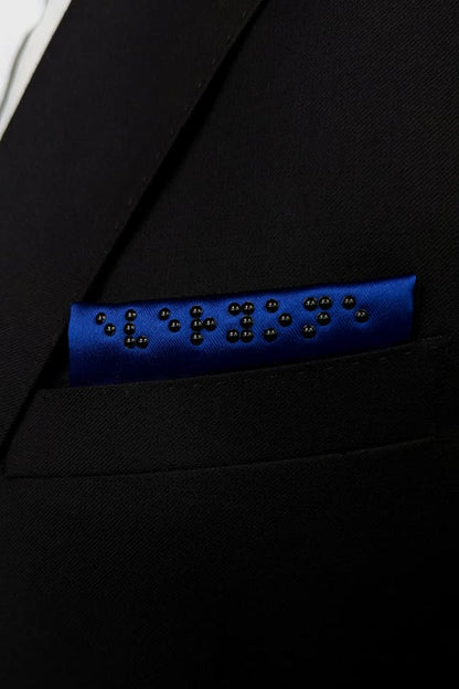 Close up of blue folded pocket square in black suit.