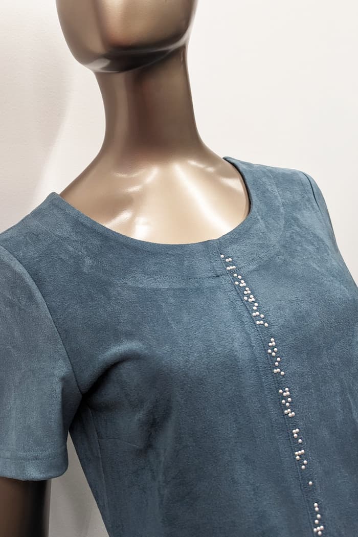Close up of blue suede dress with white braille