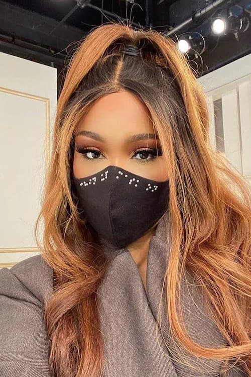 Black celebrity female wearing black braille mask