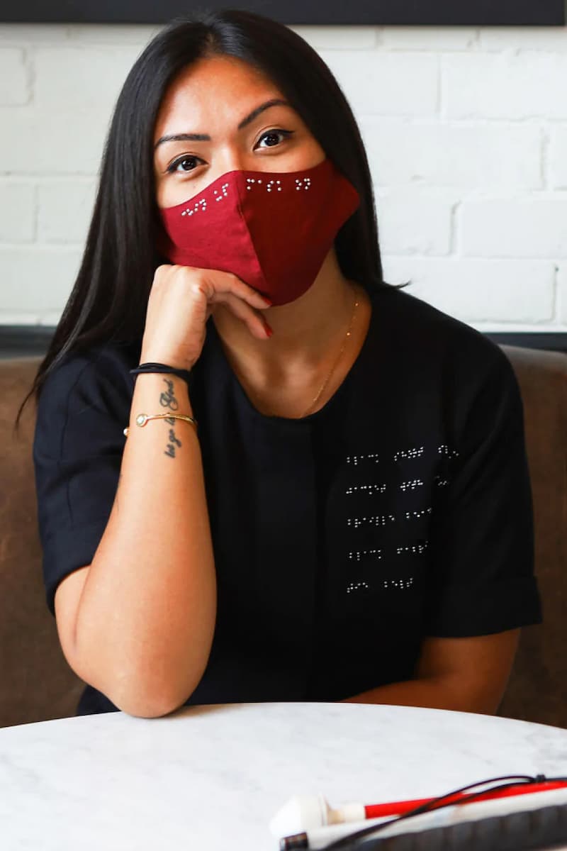 Visually impaired asian woman wearing burgundy red braille mask
