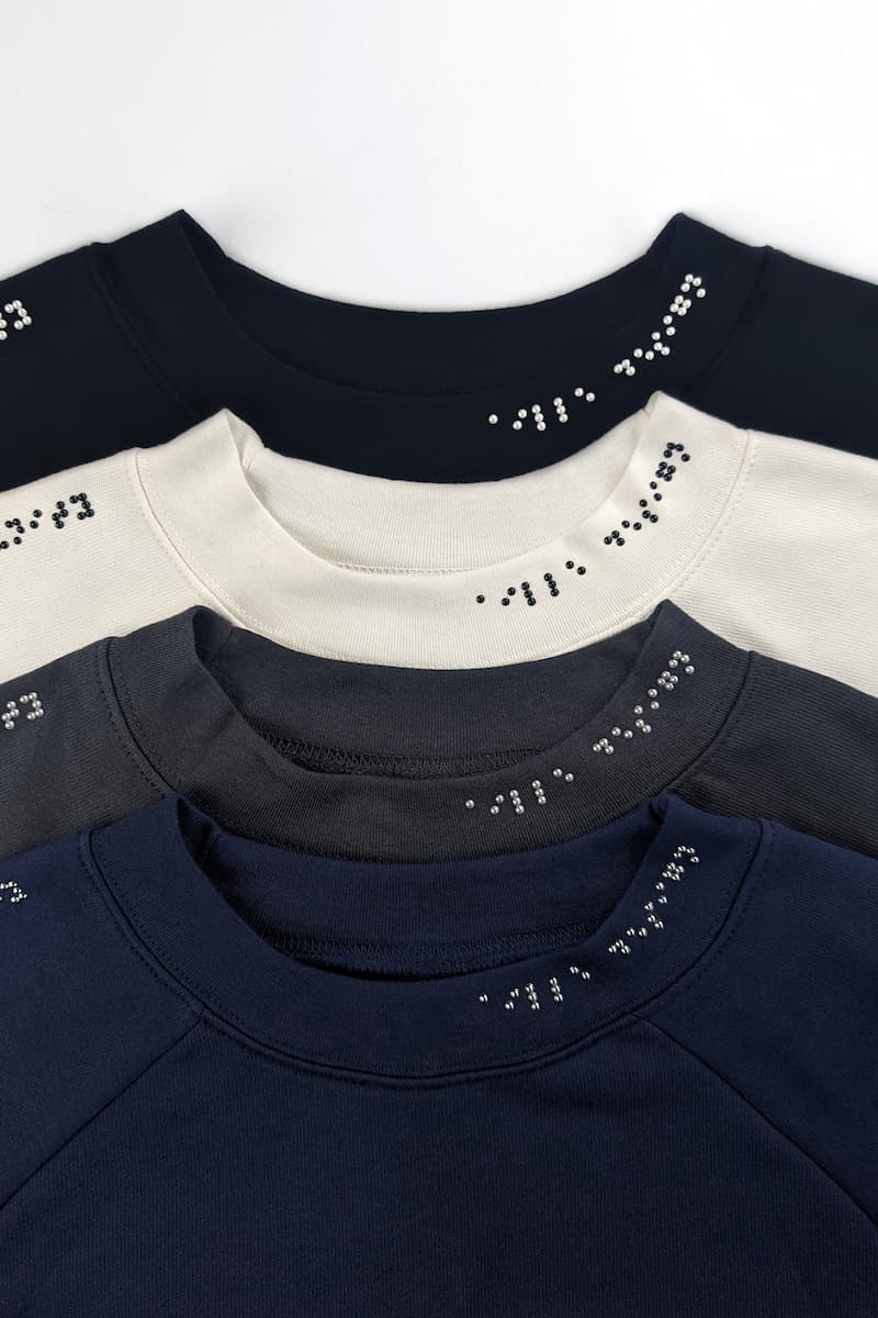 Braille sweater designs in black, cream, dark grey, and navy blue