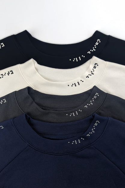 Braille sweater designs in black, cream, dark grey, and navy blue