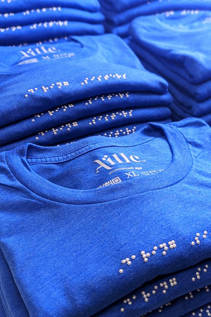 Bulk order of royal blue t-shirts with white braille beadwork