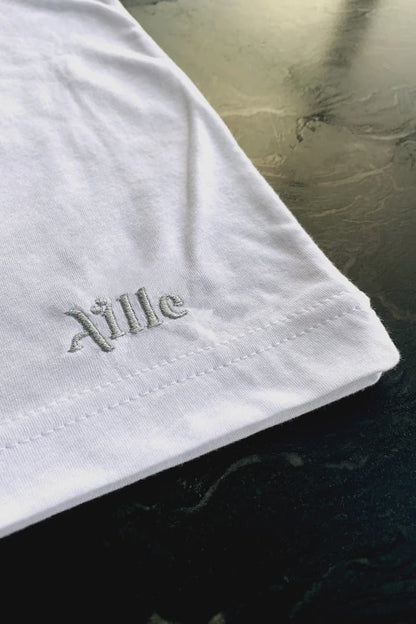 Close up of silver logo embroidery on white t-shirt
