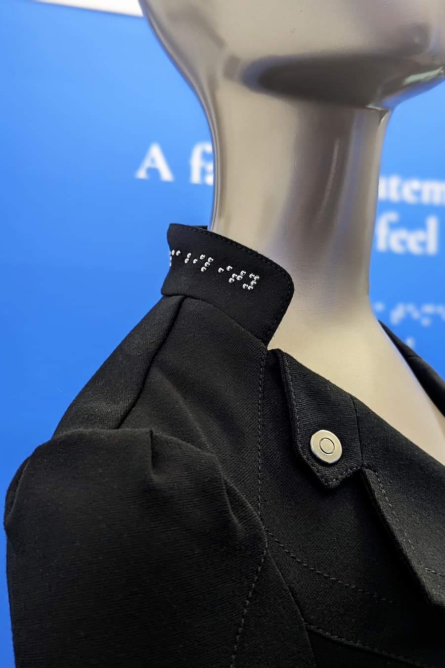 Braille beadwork on stand collar of motto jacket