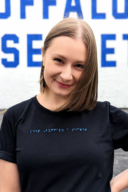 Close up of Alexa wearing black t-shirt with blue braille