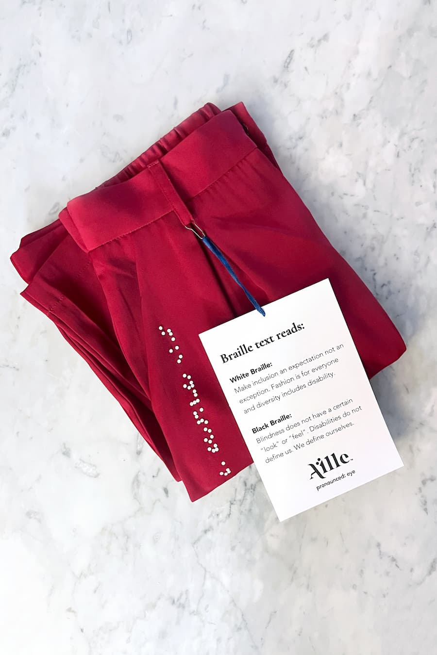 Folded red braille pants with braille description card