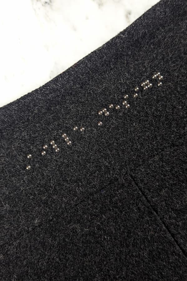 Dark grey braille beadwork on back of coat neck